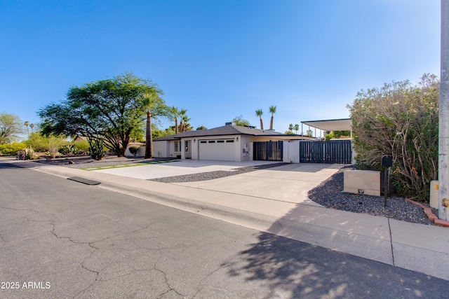 14012 N 57th Pl, Scottsdale, AZ 85254 - view of front of house featuring concrete driveway, an attached garage, stucco siding, and a gate