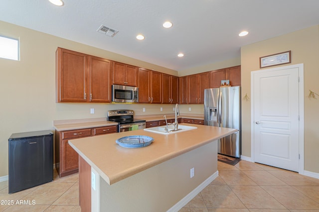 kitchen featuring stainless steel appliances, sink, a center island with sink, and light tile patterned floors