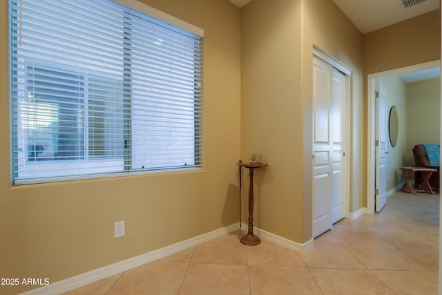 hallway featuring light tile patterned floors and a wealth of natural light