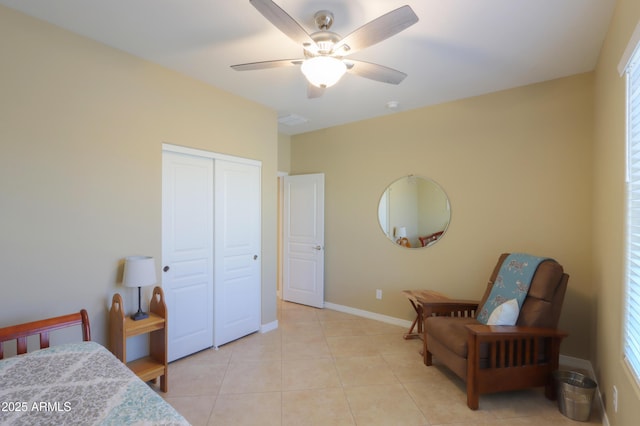 tiled bedroom featuring ceiling fan and a closet