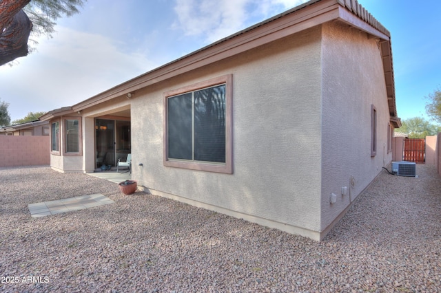 back of house with central air condition unit and a patio area