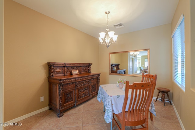 tiled dining room with an inviting chandelier