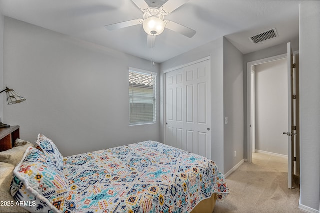 bedroom featuring ceiling fan, light carpet, and a closet