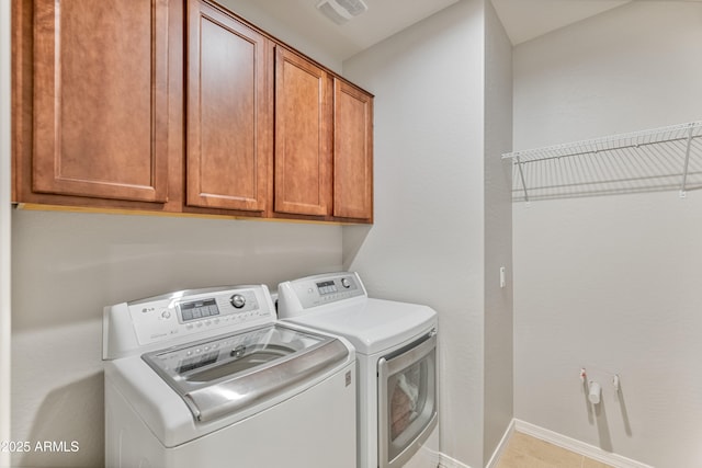 laundry room with cabinets, washing machine and dryer, and tile patterned flooring