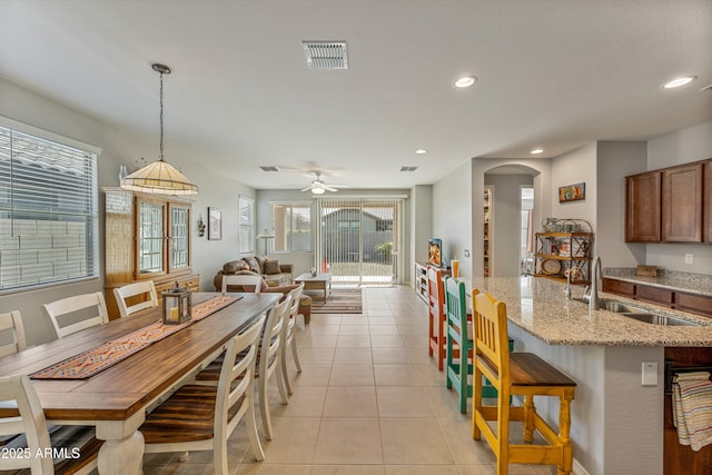 dining area with sink, light tile patterned floors, and ceiling fan