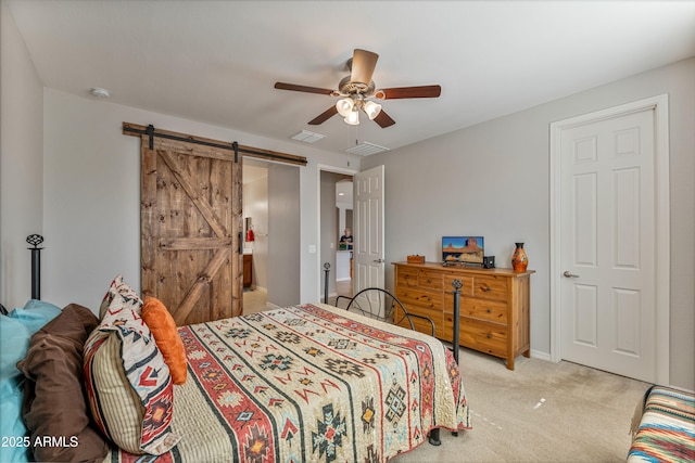 bedroom featuring a barn door, light carpet, and ceiling fan