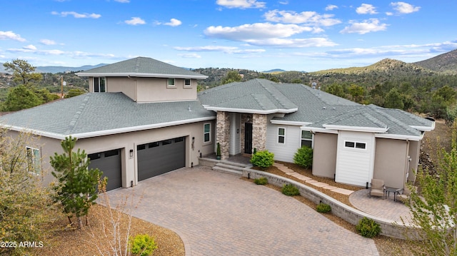 1417 Eureka Ridge Way, Prescott, AZ 86303 - view of front facade with a mountain view, a shingled roof, stucco siding, decorative driveway, and a garage