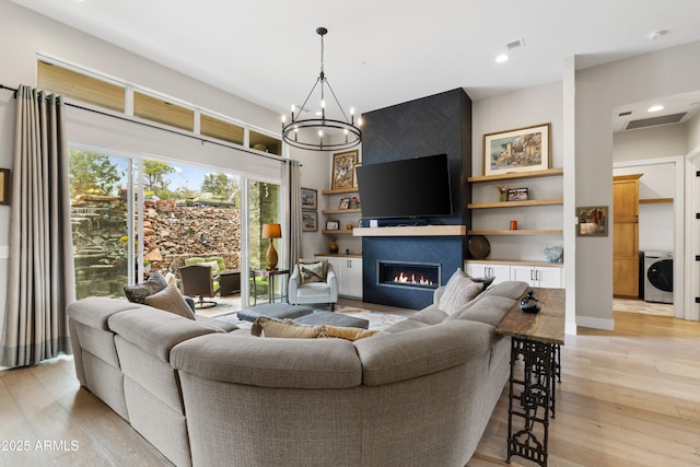 1417 Eureka Ridge Way, Prescott, AZ 86303 - living room featuring washer / clothes dryer, a fireplace, light wood finished floors, a chandelier, and recessed lighting