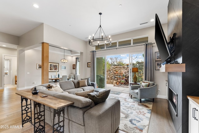 1417 Eureka Ridge Way, Prescott, AZ 86303 - living area featuring a large fireplace, light wood-type flooring, a chandelier, recessed lighting, and baseboards
