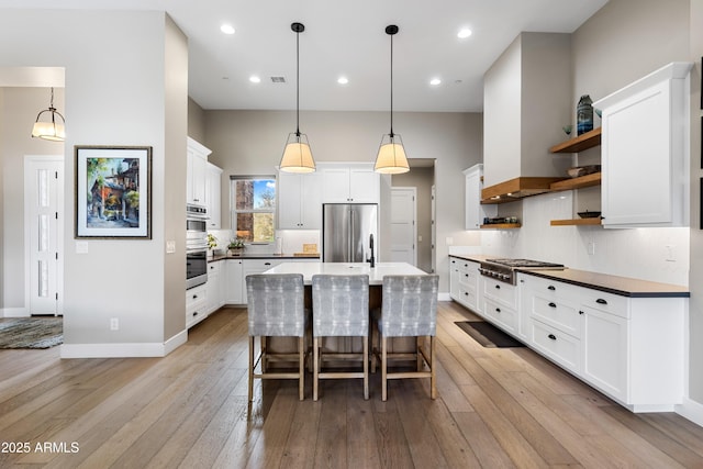 1417 Eureka Ridge Way, Prescott, AZ 86303 - kitchen with stainless steel appliances, open shelves, light wood finished floors, white cabinetry, and tasteful backsplash