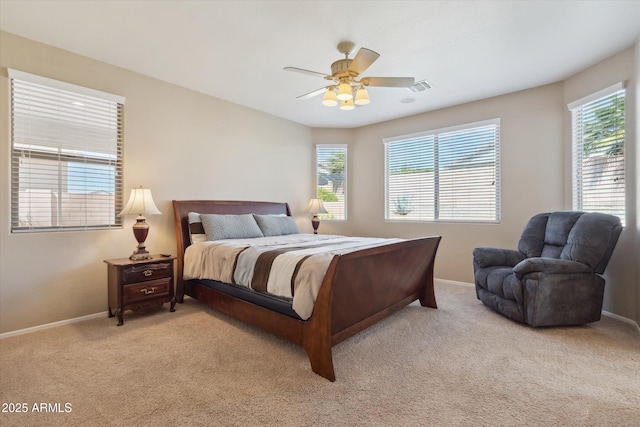 bedroom with a ceiling fan, visible vents, baseboards, and light carpet