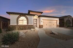 mediterranean / spanish home with stucco siding, driveway, and an attached garage