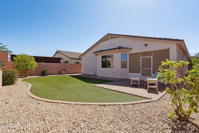 rear view of property featuring stucco siding, a patio, a yard, and a fenced backyard