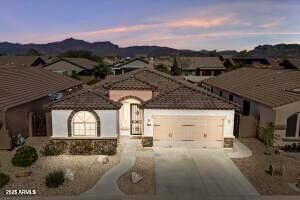 view of front facade with concrete driveway, an attached garage, and a tile roof