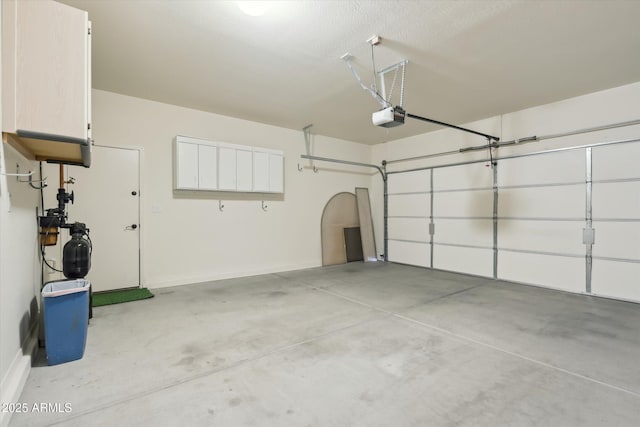 garage featuring a garage door opener and baseboards