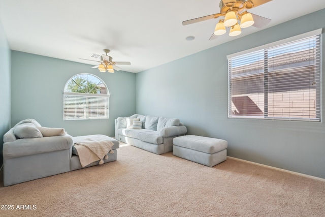 carpeted living area with visible vents, baseboards, and ceiling fan