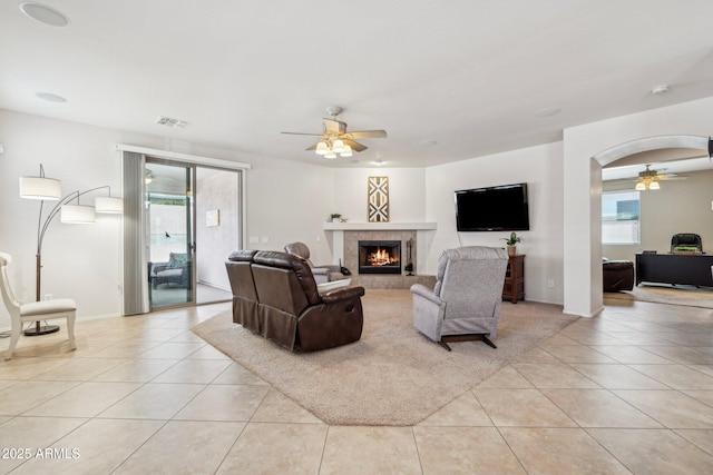 living area featuring light tile patterned floors, visible vents, and ceiling fan