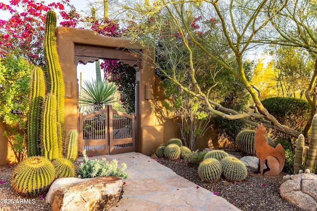 property entrance featuring a gate and stucco siding