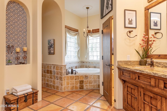 full bath featuring a bath, tile patterned floors, vanity, and a chandelier