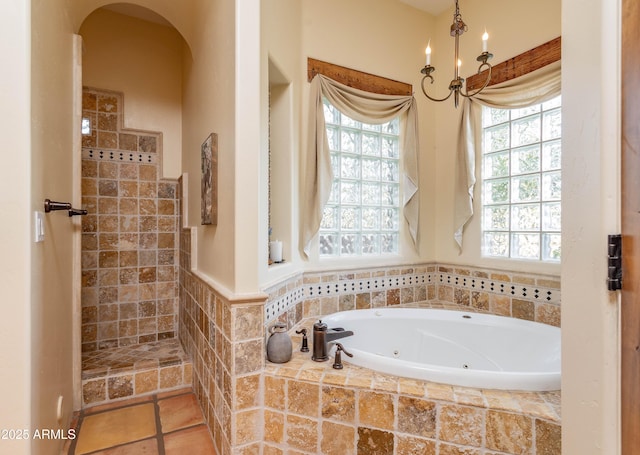 full bathroom featuring tiled shower, a chandelier, and a jetted tub