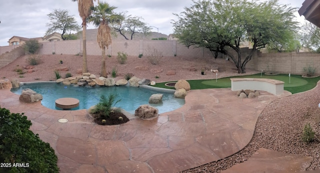 view of swimming pool with a putting area, a fenced backyard, and a patio