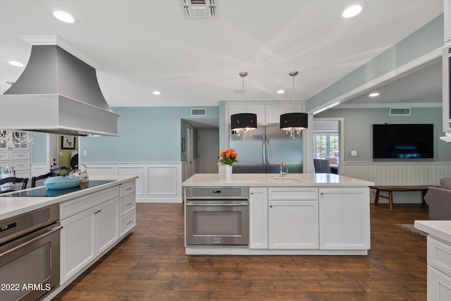 kitchen featuring hanging light fixtures, stainless steel appliances, dark hardwood / wood-style floors, white cabinets, and island exhaust hood