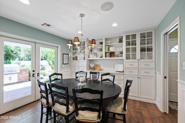 dining space with dark hardwood / wood-style flooring, french doors, and a chandelier