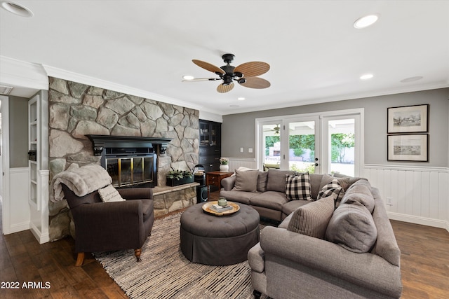 living room with crown molding, a stone fireplace, and dark hardwood / wood-style flooring