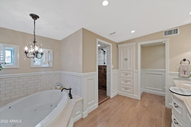 bathroom with lofted ceiling, vanity, a notable chandelier, wood-type flooring, and shower with separate bathtub