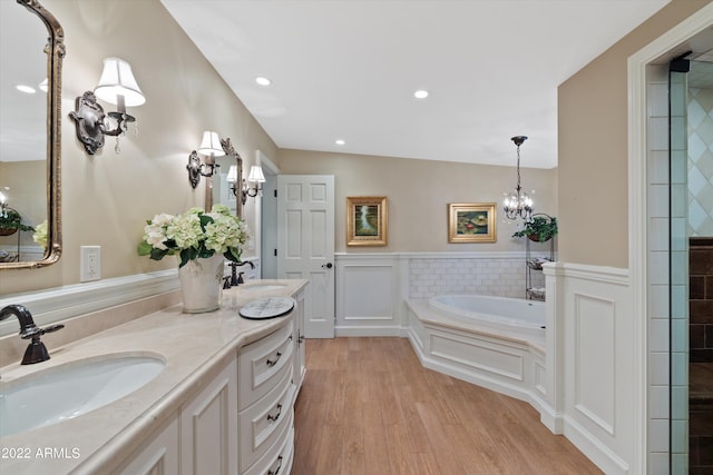 bathroom with wood-type flooring, a bath, and vanity