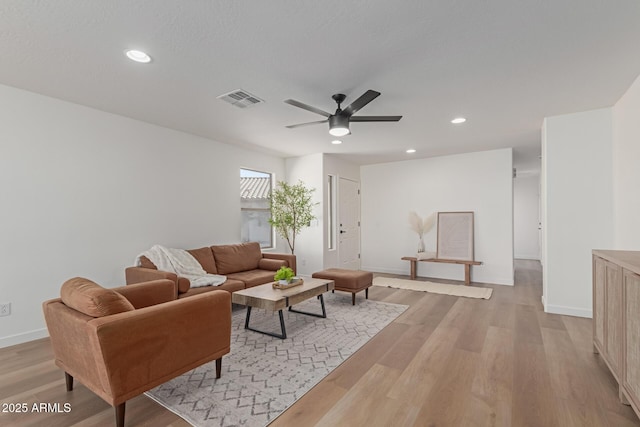 living room with ceiling fan and light hardwood / wood-style flooring