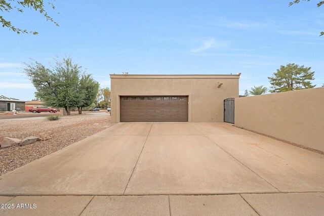 1444 E Myrna Ln, Tempe, AZ 85284 - view of side of home featuring stucco siding, a garage, a gate, and concrete driveway