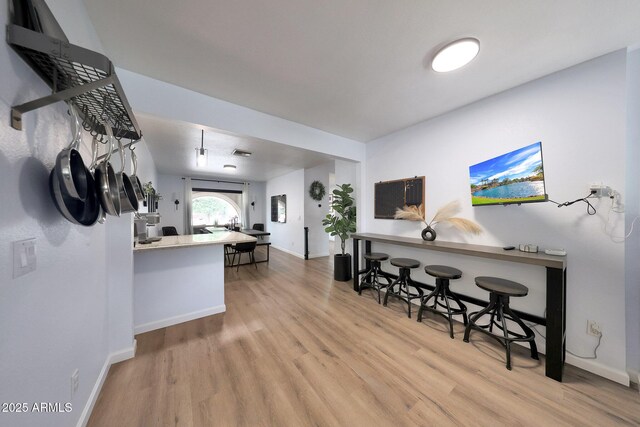 1444 E Myrna Ln, Tempe, AZ 85284 - kitchen featuring wood finished floors, baseboards, and a breakfast bar area