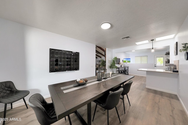 1444 E Myrna Ln, Tempe, AZ 85284 - dining room featuring wood finished floors, baseboards, a skylight, and a textured ceiling