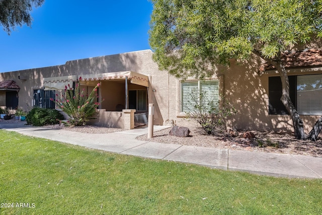 view of front of house featuring stucco siding and a front lawn