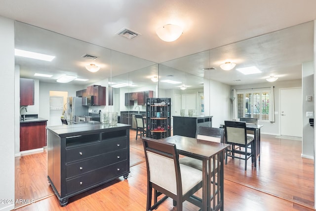 dining space featuring baseboards, visible vents, and light wood-type flooring