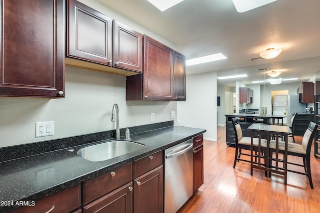 kitchen with visible vents, light wood-style flooring, a sink, stainless steel dishwasher, and dark brown cabinetry