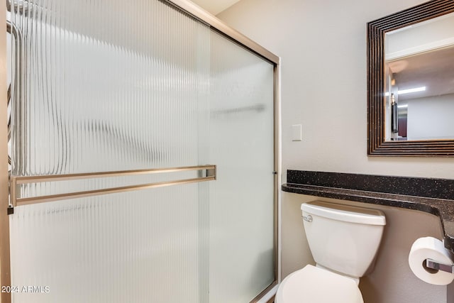 full bathroom with a shower stall and toilet