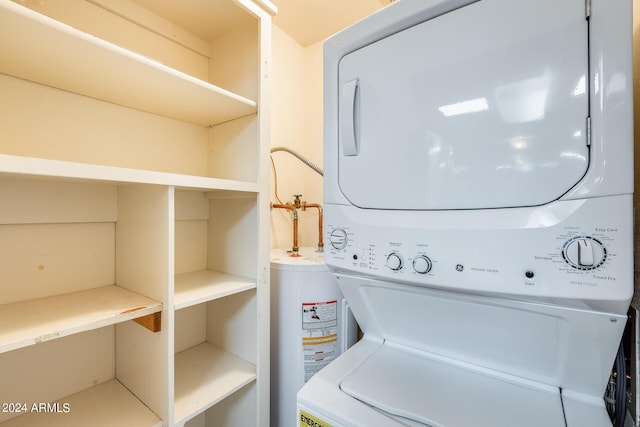 clothes washing area featuring stacked washer and dryer, water heater, and laundry area