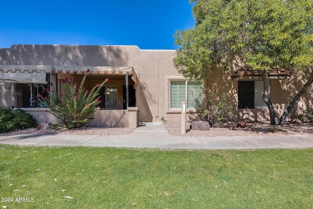 view of front of property with stucco siding and a front lawn