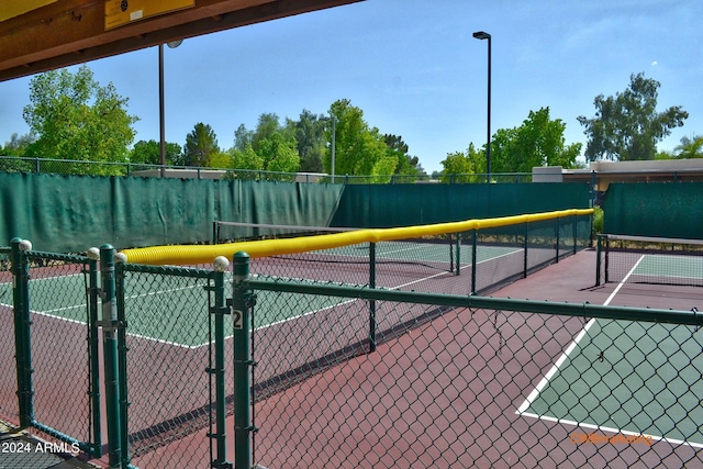 view of tennis court featuring fence