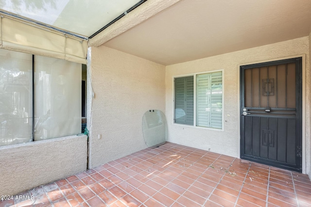 entrance to property with a patio and stucco siding