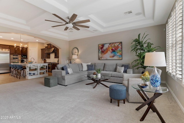 9608 N 184th Ln, Waddell, AZ 85355 - living room featuring arched walkways, a ceiling fan, light colored carpet, coffered ceiling, and a chandelier