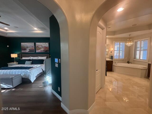 9608 N 184th Ln, Waddell, AZ 85355 - hall featuring a raised ceiling, arched walkways, a chandelier, and recessed lighting