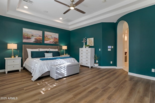 9608 N 184th Ln, Waddell, AZ 85355 - bedroom featuring a raised ceiling, arched walkways, wood finished floors, baseboards, and recessed lighting