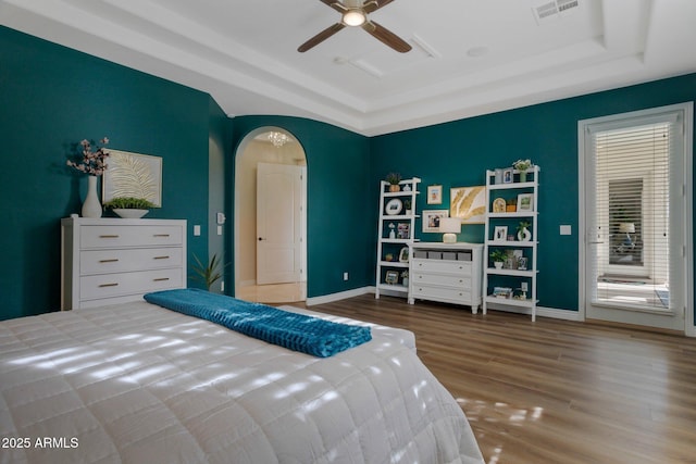 9608 N 184th Ln, Waddell, AZ 85355 - bedroom with a tray ceiling, wood finished floors, arched walkways, and baseboards