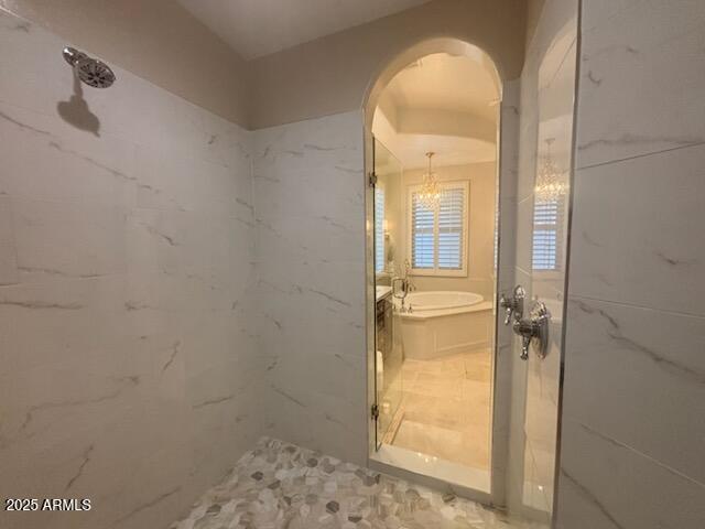 9608 N 184th Ln, Waddell, AZ 85355 - bathroom featuring a chandelier, a bath, and a marble finish shower