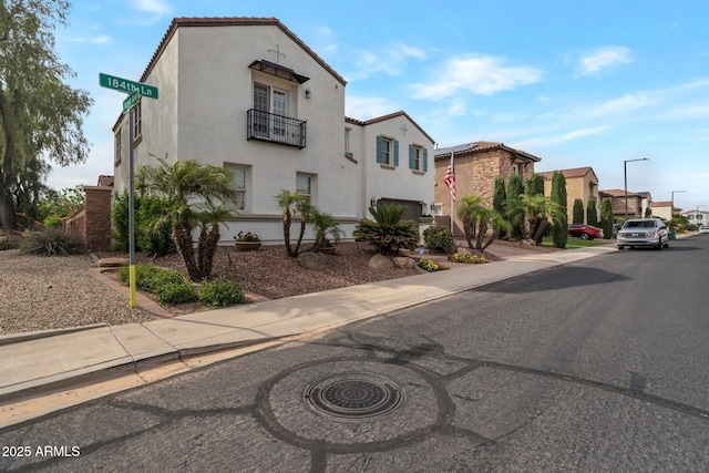 9608 N 184th Ln, Waddell, AZ 85355 - mediterranean / spanish-style home with stucco siding, a tiled roof, a balcony, and a residential view