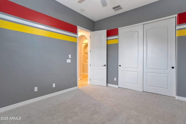 9608 N 184th Ln, Waddell, AZ 85355 - unfurnished bedroom with arched walkways, carpet, baseboards, a closet, and ceiling fan