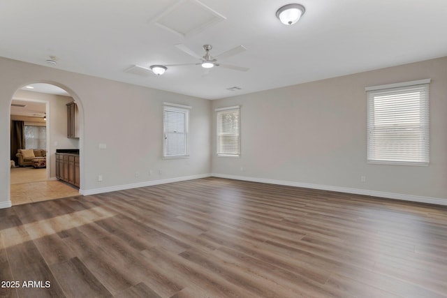 9608 N 184th Ln, Waddell, AZ 85355 - unfurnished room with light wood finished floors, arched walkways, baseboards, and a smoke detector